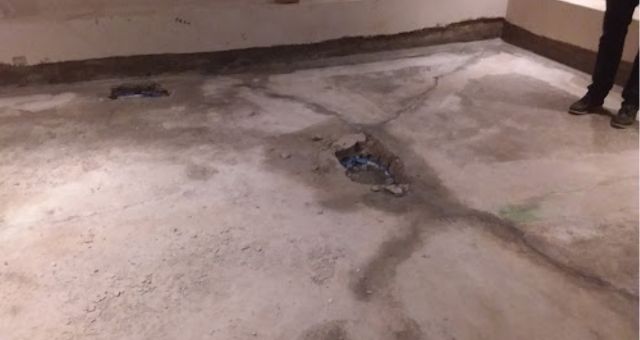 Bending stresses can cause cracking and permanent damage to the structure of a property. In this example, the floor has heaved upwards, causing cracks and water ingress.