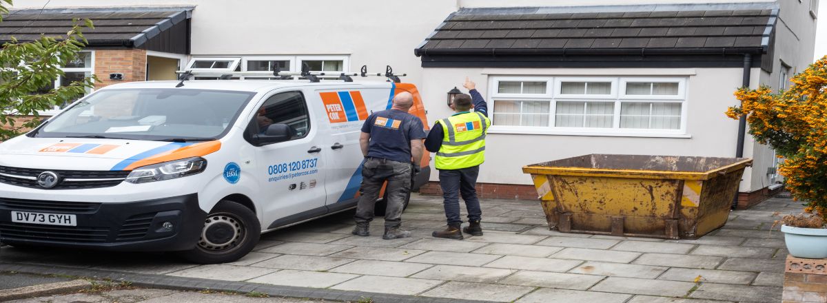 PeterCox surveyor and technician assessing a roof from the outside whilst standing next to PeterCox company van