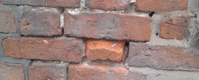 Spalling brickwork and algae growth