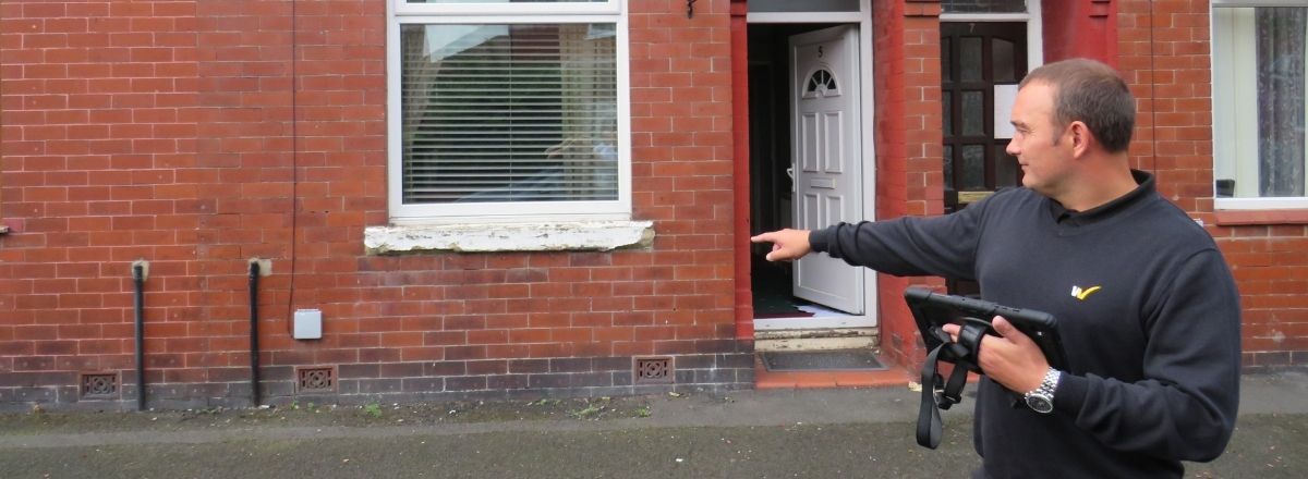 Surveyor pointing at wall