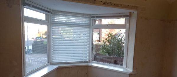The result of condensation under bay windows; condensation puddles and damp staining under and above window frame
