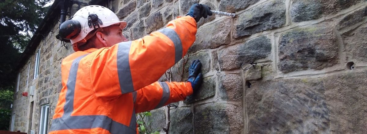 Technician inserting sock anchors into wall