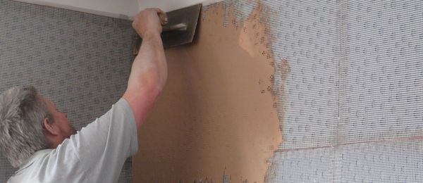 Wise Property Care technician applying a complete multi-layer thermal plastering system to a cold internal wall